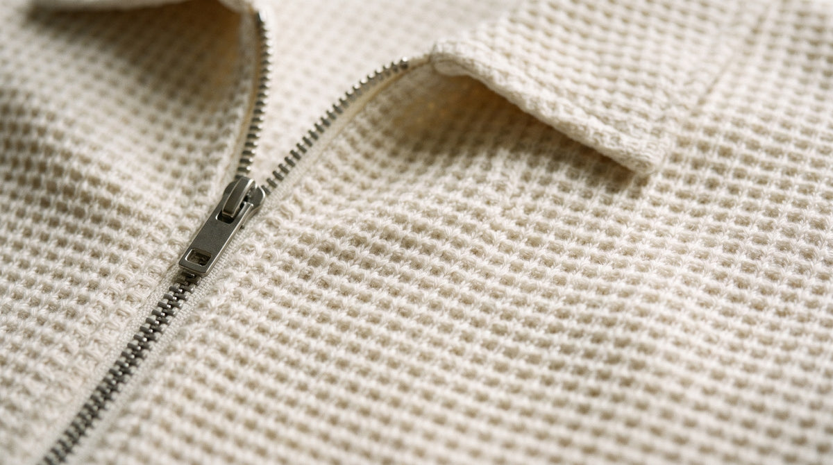 Close-up of ecru waffle-knit fabric and zip
